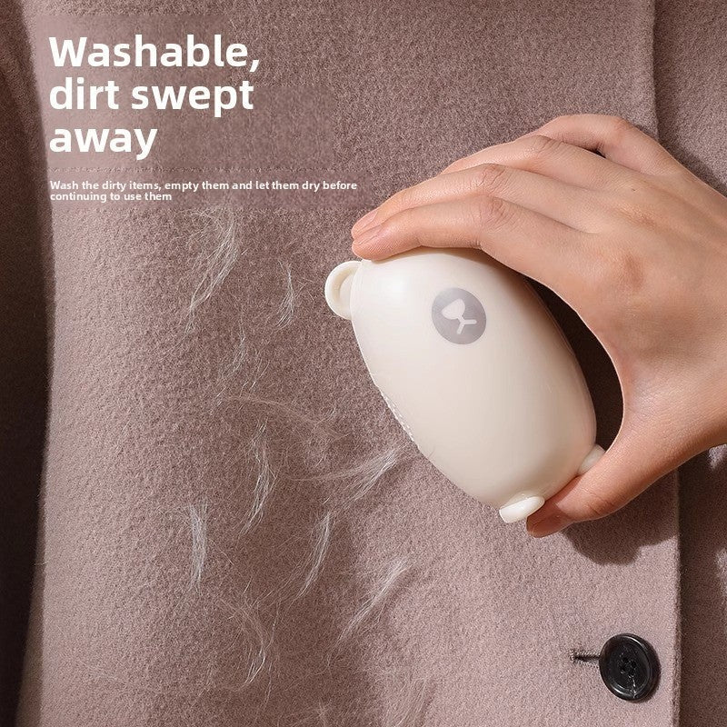 ShopTrendora™ reusable lint roller in milky white, shaped like a bear, effectively removes pet hair and lint from clothing.